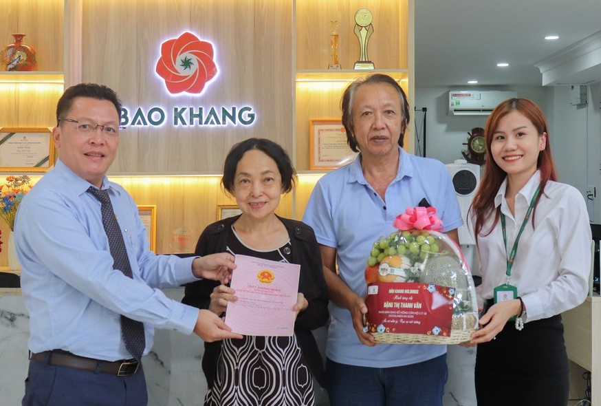 Anh Lê Tấn Trung - đại diện công ty Bảo Khang trao sổ hồng cho khách hàng